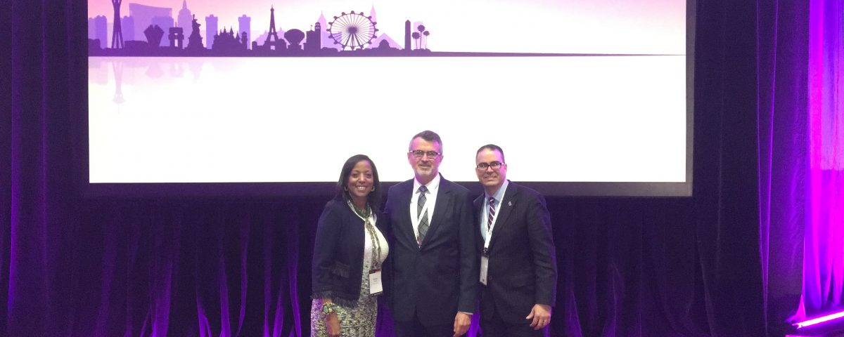 Denise Thomas (left), director of Africa and Middle East Trade and Melvin Torres (right), director of Latin America Trade stand with Scott Ferguson, president of the World Trade Centers Association at the General Assembly.