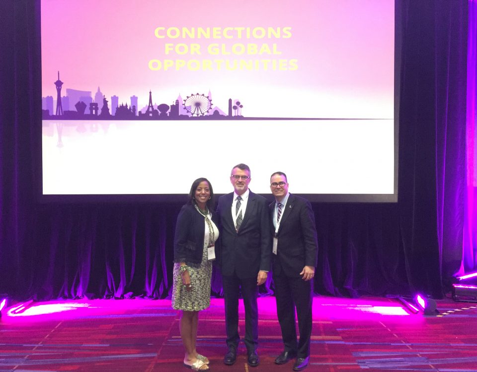 Denise Thomas (left), director of Africa and Middle East Trade and Melvin Torres (right), director of Latin America Trade stand with Scott Ferguson, president of the World Trade Centers Association at the General Assembly.